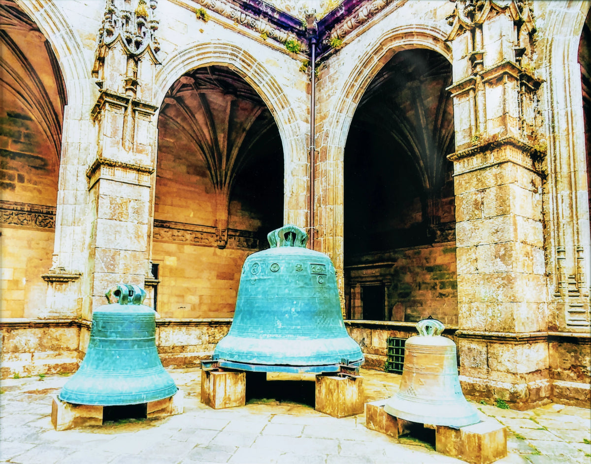 Camino de Santiago monastery courtyard with three large bronze bells